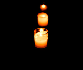 Set of lighting candles in a row on dark background