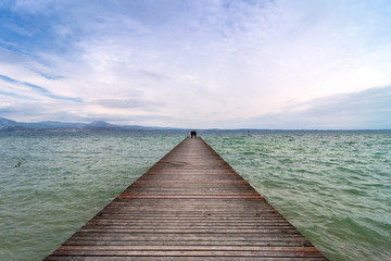 wooden pier and sky over Garda lake - Italy