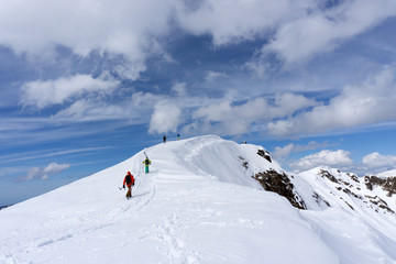 Naklejka na ściany i meble Skiers climbing a snowy mountain