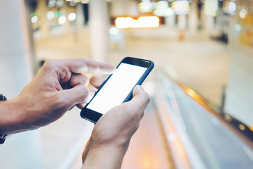 Back view of male hands using modern smartphone with blank screen