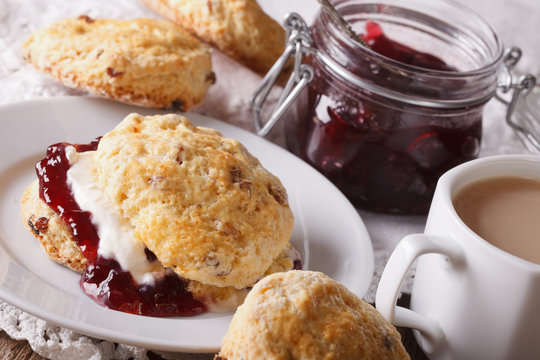 English pastries: scones with jam and tea with milk close-up. Horizontal
