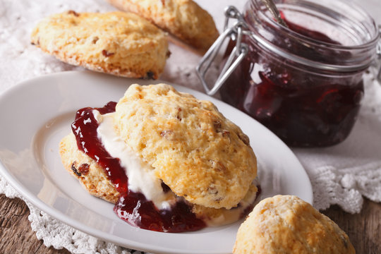 British scones with jam and whipped cream close-up. Horizontal
