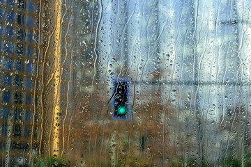 Traffic lights behind car window in rainy day