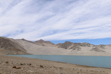 Fototapeta na wymiar Landscape of Karakul lake, in Xinjiang province of China lies on the Karakoram Highway linking Kashgar in China with Islamabad in Pakistan. It's in the Pamir mountain range.