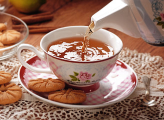 versare il tè caldo nella tazza di porcellana