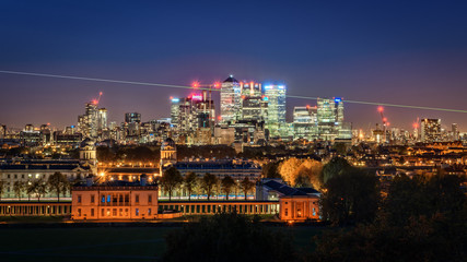 Night view to Greenwich, prime meridian beam and Canary Wharf in