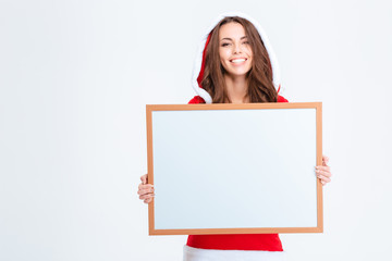 Smiling woman in santa claus cloth holding blank board