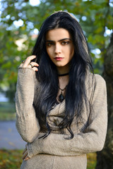Portrait of a beautiful gothic girl with tree background