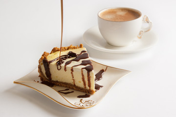 Piece of cheesecake pour a thin stream of chocolate