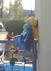 Textile handmade doll in a blue coat and blond hair