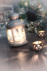 Decorative lantern, candles and Christmas wreath on vintage kitc