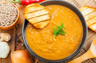 Delicious cream soup made of lentil and vegetables on table, close-up, top view