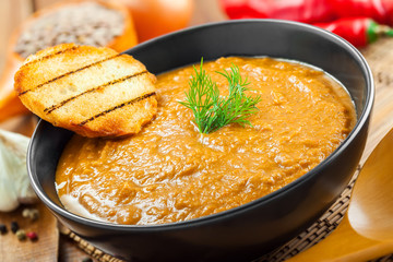 Lentil cream soup on wooden table, healthy food cooking