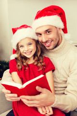smiling father and daughter reading book