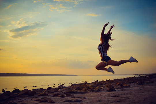 Image of beautiful young lady having fun jumping high over open water on summer outdoors background copy space