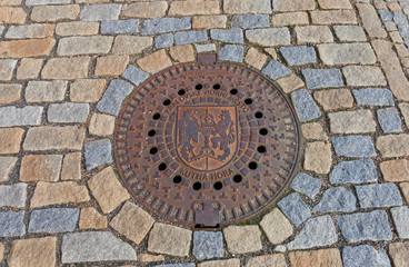 Sewer manhole with сoat of arms of Kutna Hora, Czech Republic