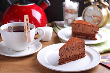 slice of chocolate cake on a white plate decorated with white vase of flowers