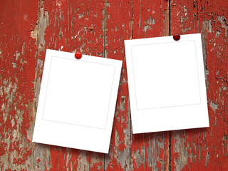 Two square photo frames with pins on red wooden boards background