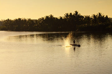Fisherman is fishing in sunrise at Thu Bon river, Cua Dai, Quang Nam, Vietnam