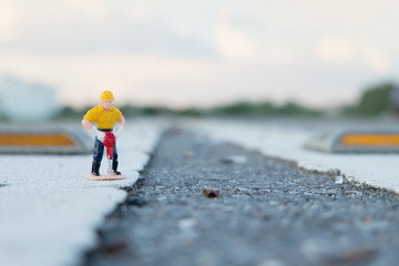 single focus small figure of a man digging concrete road