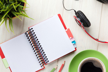 Obraz na płótnie Canvas Desk with notepad, coffee and headphones