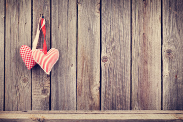 Two Valentines day hearts on rustic wooden wall