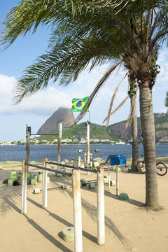 Iron and concrete weights and rustic bars of an outdoor workout station in the Flamengo neighborhood of Rio de Janeiro with view of Sugarloaf Mountain