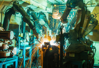 Team Robot welding movement Industrial automotive part in factory