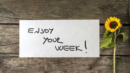 Obraz premium Enjoy your week message written on white paper