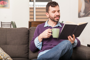 Man relaxing and reading at home