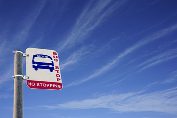 Bus stop sign on blue sky