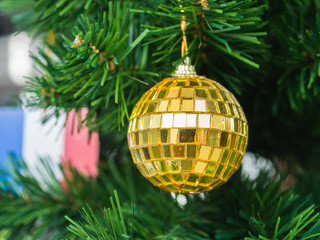 Golden Christmas ball on christmas tree with blurry France flag