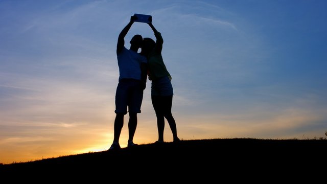 Lovers do selfie at sunset.