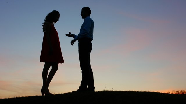 Guy doing the proposal for girl against a beautiful sky.   