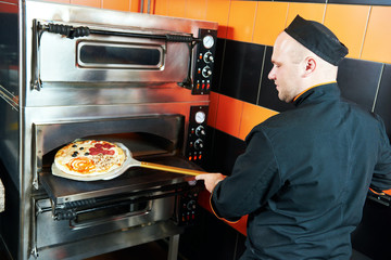 chef baker cook putting pizza in the oven