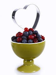 A bowl with cranberries and the silhouette of a heart