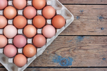 Chicken brown eggs in packing on a timber floor, the top view. F