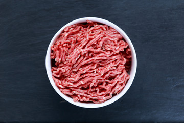 Fresh raw minced beef on old blue stone background
