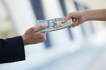 business woman and a businessman hold money