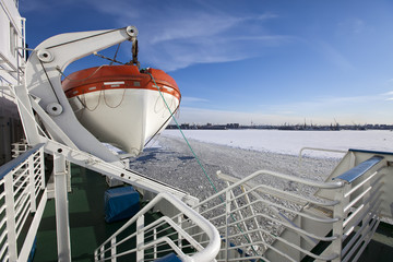 View from the Gulf of Finland covered with ice on St. Petersburg seaport and a lifeboat from a...