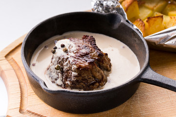 Fried meat in a pan in a creamy sauce