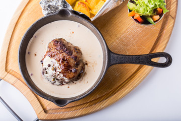 Fried meat in a pan in a creamy sauce