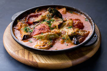 Mix steamed vegetables in a pan on dark table