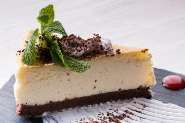 Delicious cheesecake with strawberry syrup on white wooden table
