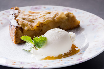 Piece of cake charlotte with apples ice cream and fresh mint on