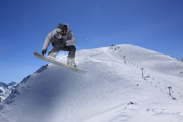 Flying snowboarder on mountains. Extreme sport.