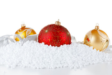 Red and gold Christmas balls on glossy surface in the snow.