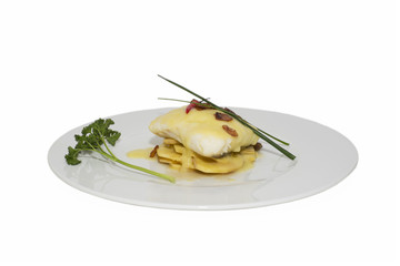 Hake fillets with cheese sauce on a bed of potatoes