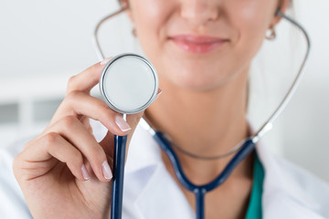 Portrait of female doctor holding stethoscope head