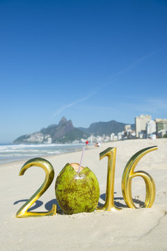 Gold 2016 message with green coco gelado drinking coconut on the beach in Rio de Janeiro, Brazil